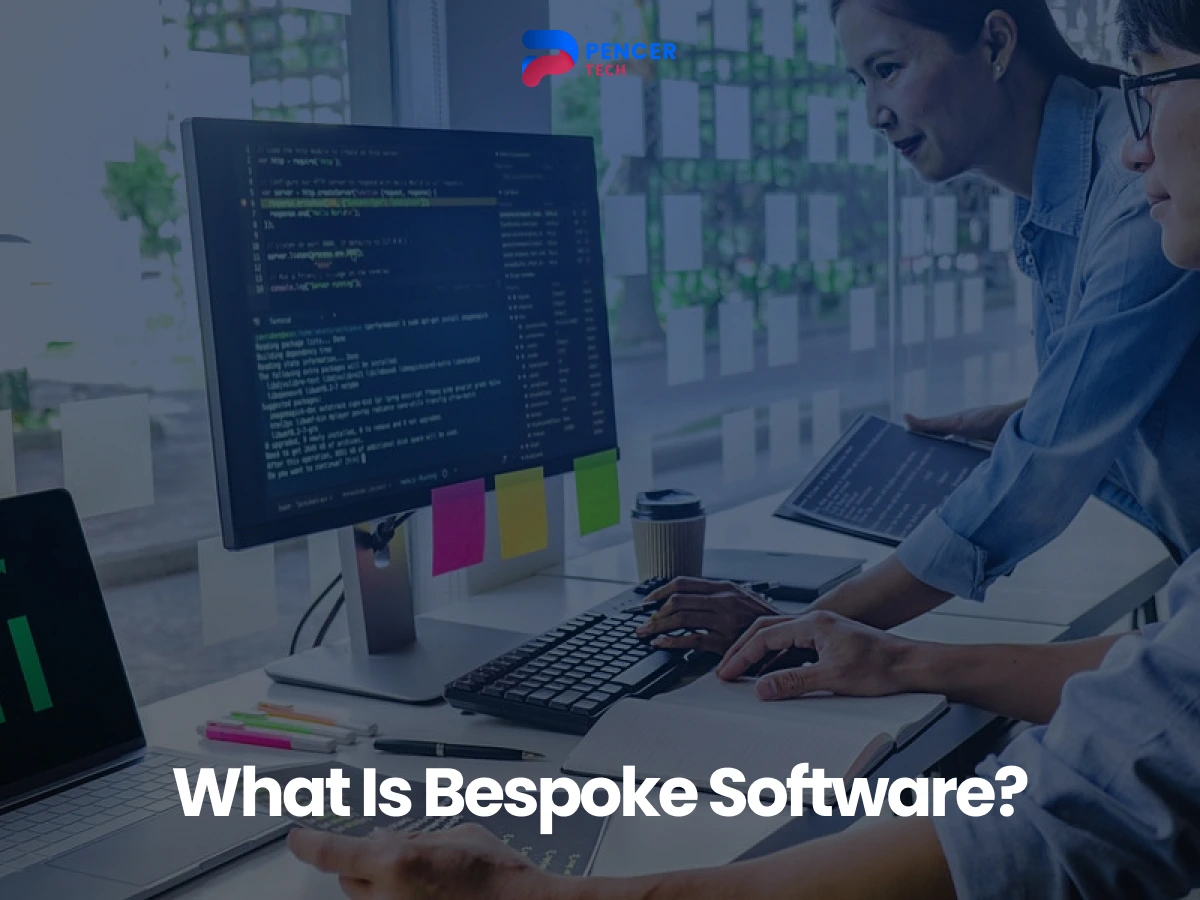 Two people working on computers in a modern office; one screen shows code. Text reads “What Is Bespoke Software?” at the bottom.